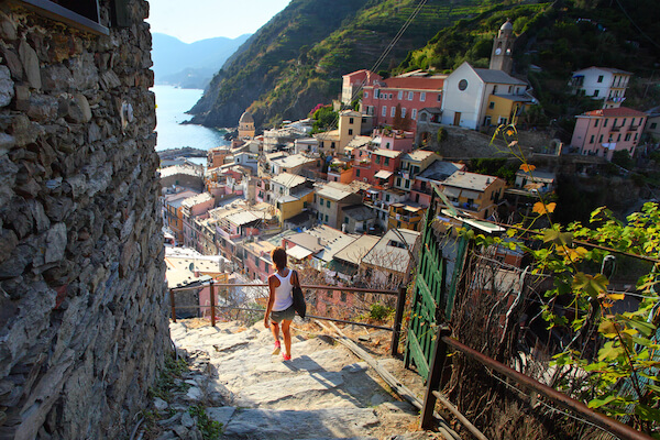 Cinque Terre packing list: woman walking down Cinque Terre path towards village