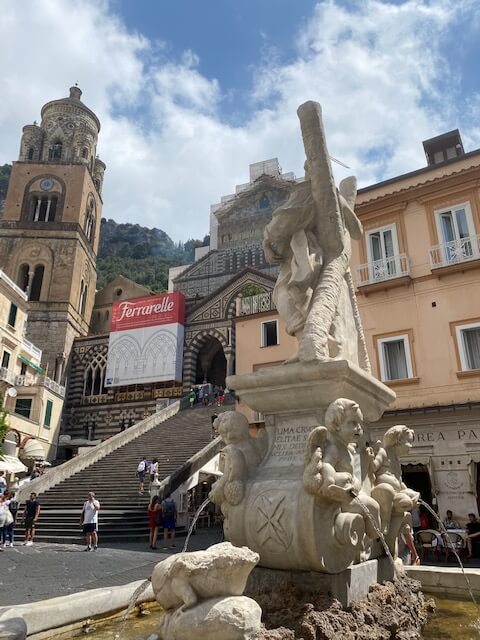 Amalfi main square with fountain, duomo and tower bell
