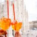 glasses of aperol spritz with the backdrop of milan duomo
