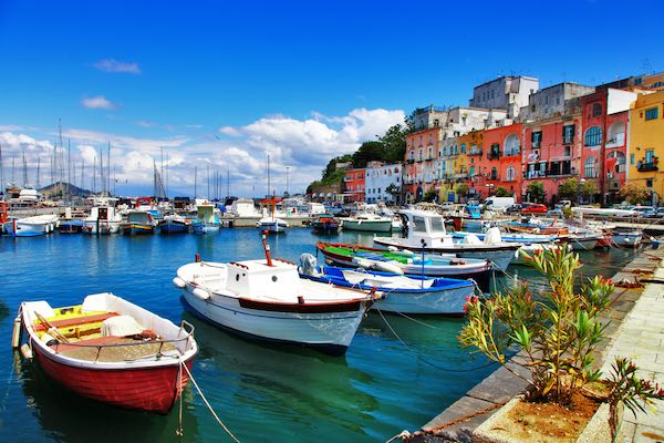 Procida sea front with small boats and colorful houses in the background