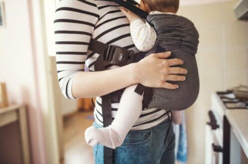 mom with baby in carrier in home kitchen