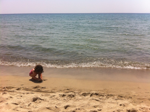 little girl on a beach in Italy in July