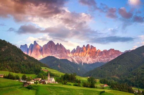 italian dolomites village with mountains at sunset