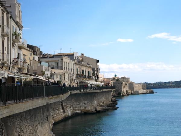 Seafront Promenade in Siracusa Sicily with while houses overlooking the blue sea