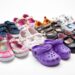many pairs of kids shoes on whote background