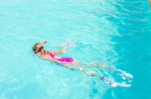 little girl snorkeling in pool