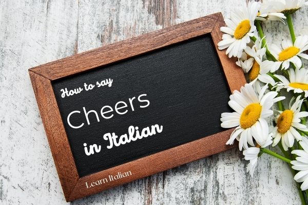blackboard with how to day cheers in Italian written on and daisies on the right hand side