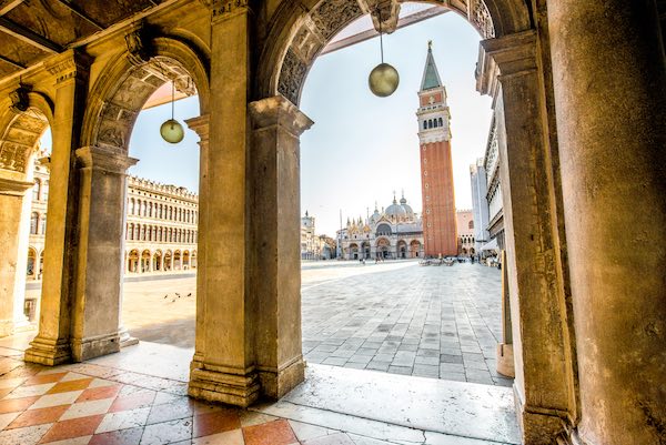 Arches of Correr museum with San Marco tower on the main square in the morning in Venice