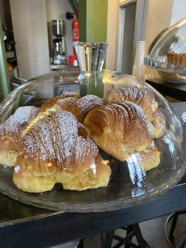 Cafe in Italy with a tray of cornetti under a glass cover