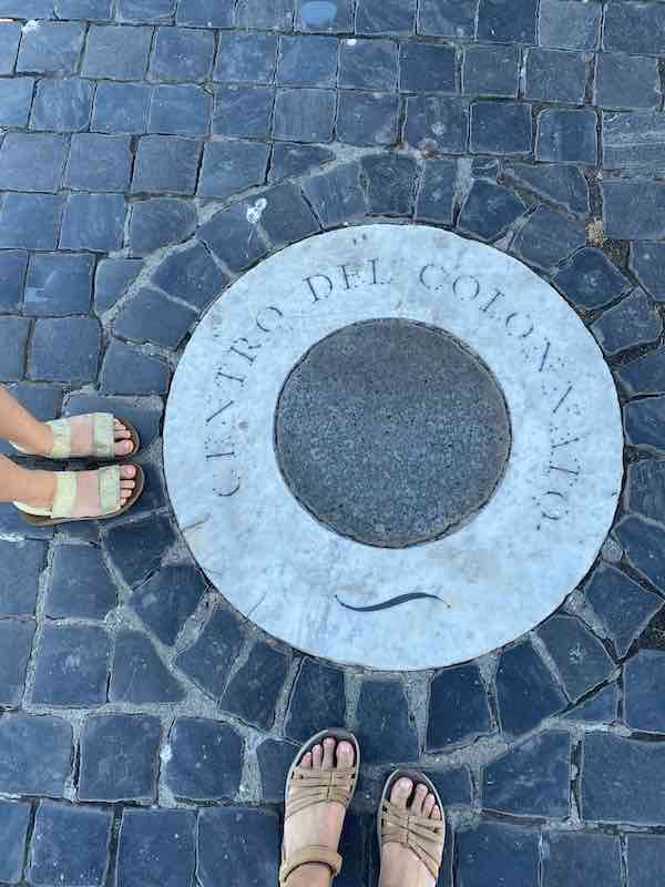 Woman feet and child feet on cobbles wearing sandals