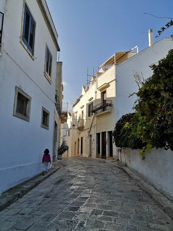 My daughter walking along a pretty street in Locorotondo Puglia with whitewashed houses