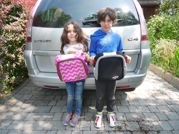 children holding their car seat