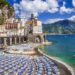 Amalfi Coast beach with beach clubs with blue umbrellas