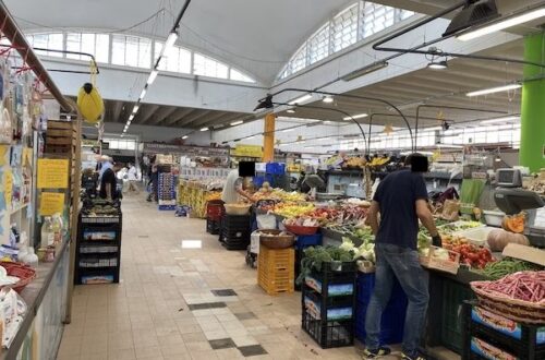 inside of food market in italy with foor stalls and people