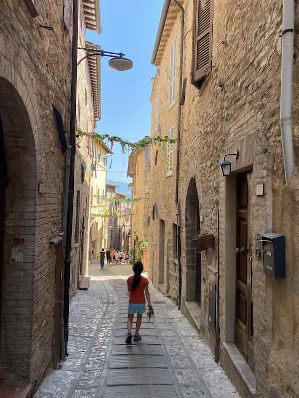 child walking along pretty street in Spello Italy