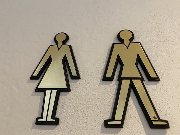 figurine of a man and a woman outside a public bathroom in Italy