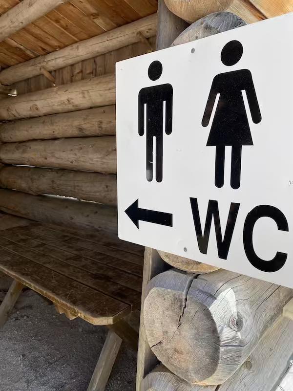 Sign to public toilet in Italy with make and female figurine and the letters WC