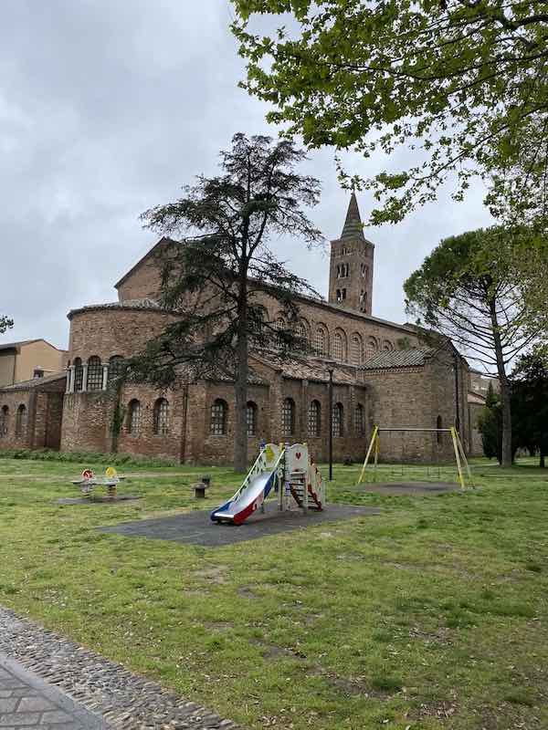 Small kids' playground rea in Ravenna city center with church in the background