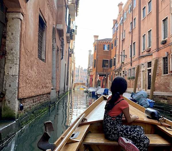 10 year old girl in Venice on a boat looking at the canals
