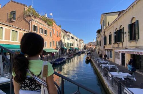 Child in Venice looking at a canal from a bridge while doing a kids' tour