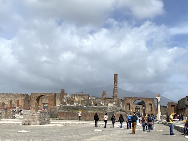 The forum of ancient Pompeii with Mount Vesuvius in the background with clouds
