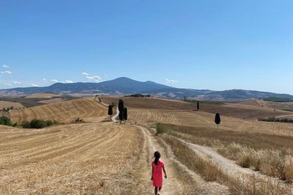 child waling in val d orcia countryside