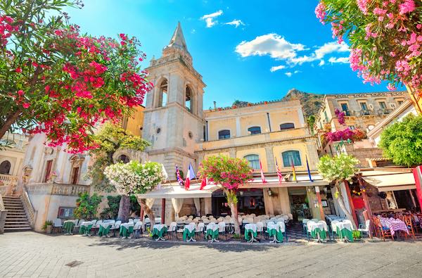 Taormina - square with outdoor tables and spring flowers in the foreground